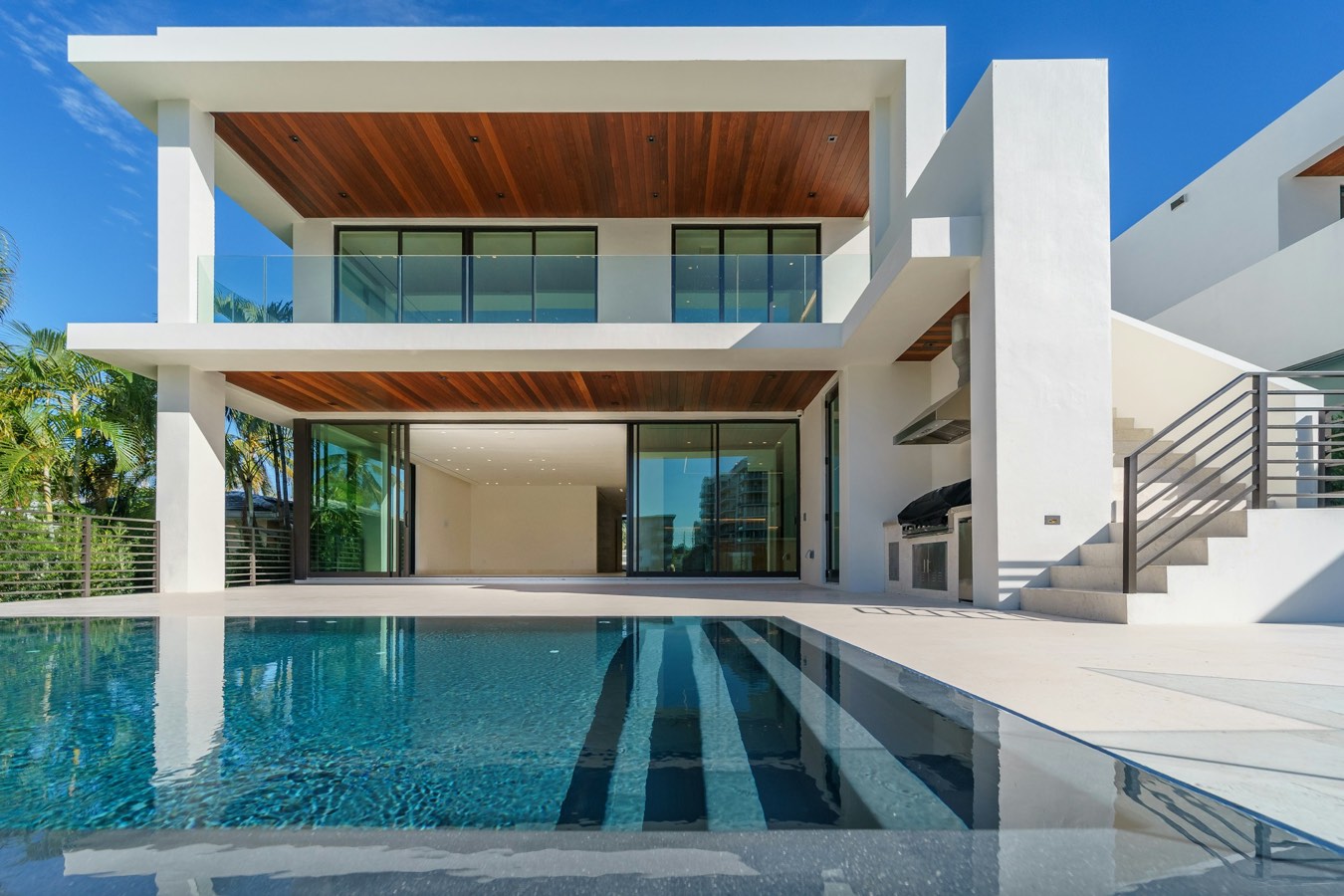 White modern villa above a long pool