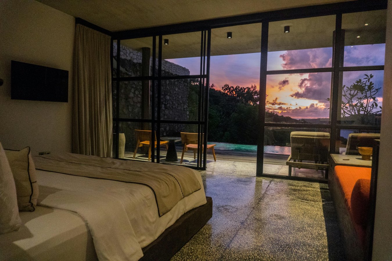 Bedroom opening onto a terrace at sunset