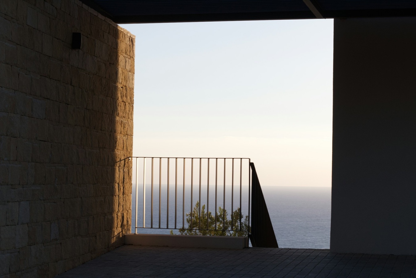 Stone balcony framing the sea at dusk