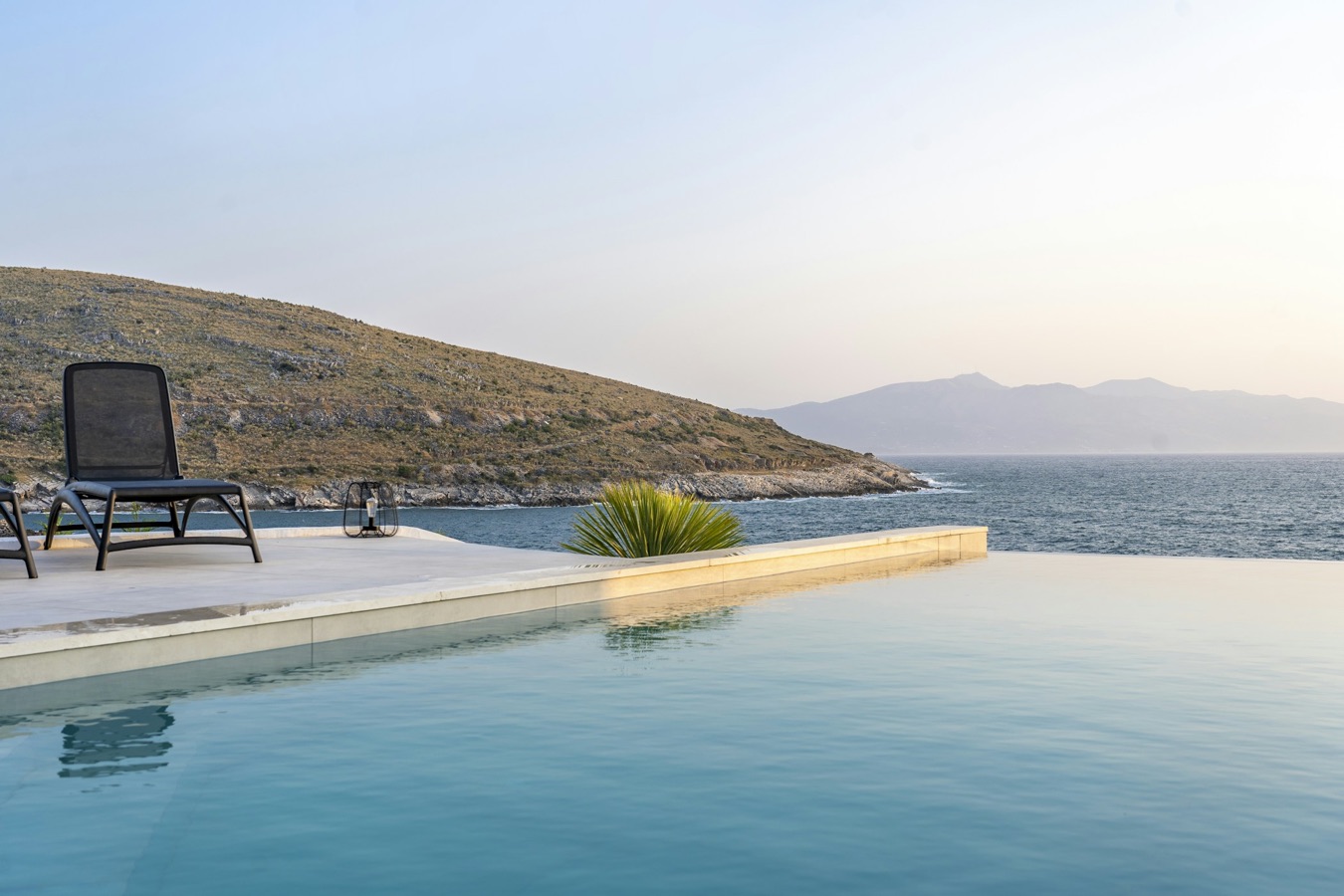 Lounger at the edge of a pool above the sea
